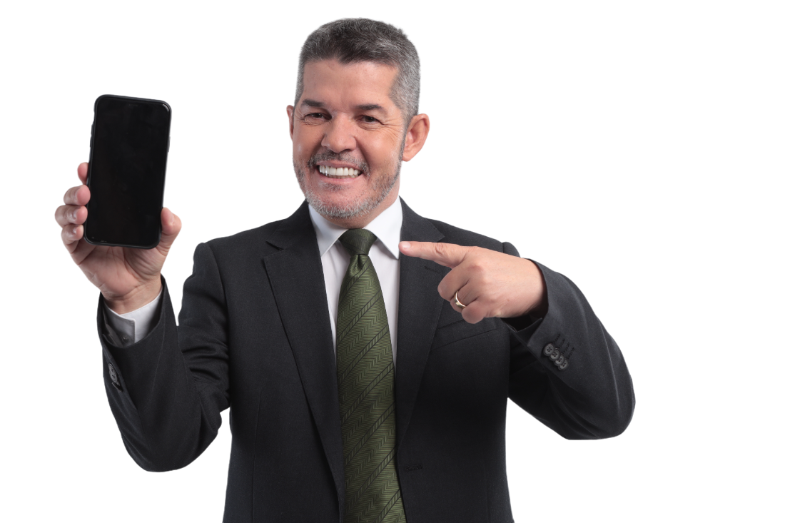 Delegado Waldir sorrindo e segurando em uma mao um celular que mostra a tela do seu instagram e sua outra tem aponta o dedo para o celular